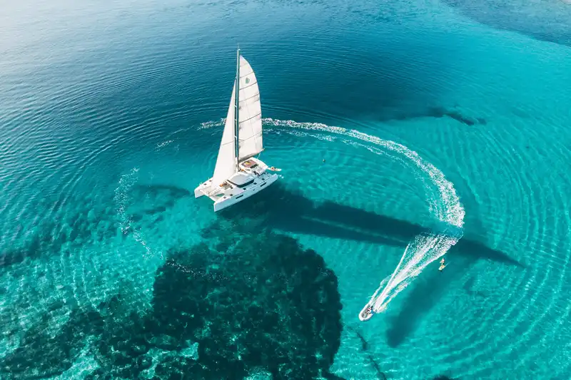 Katamaran unter Segeln im kristallklaren Wasser