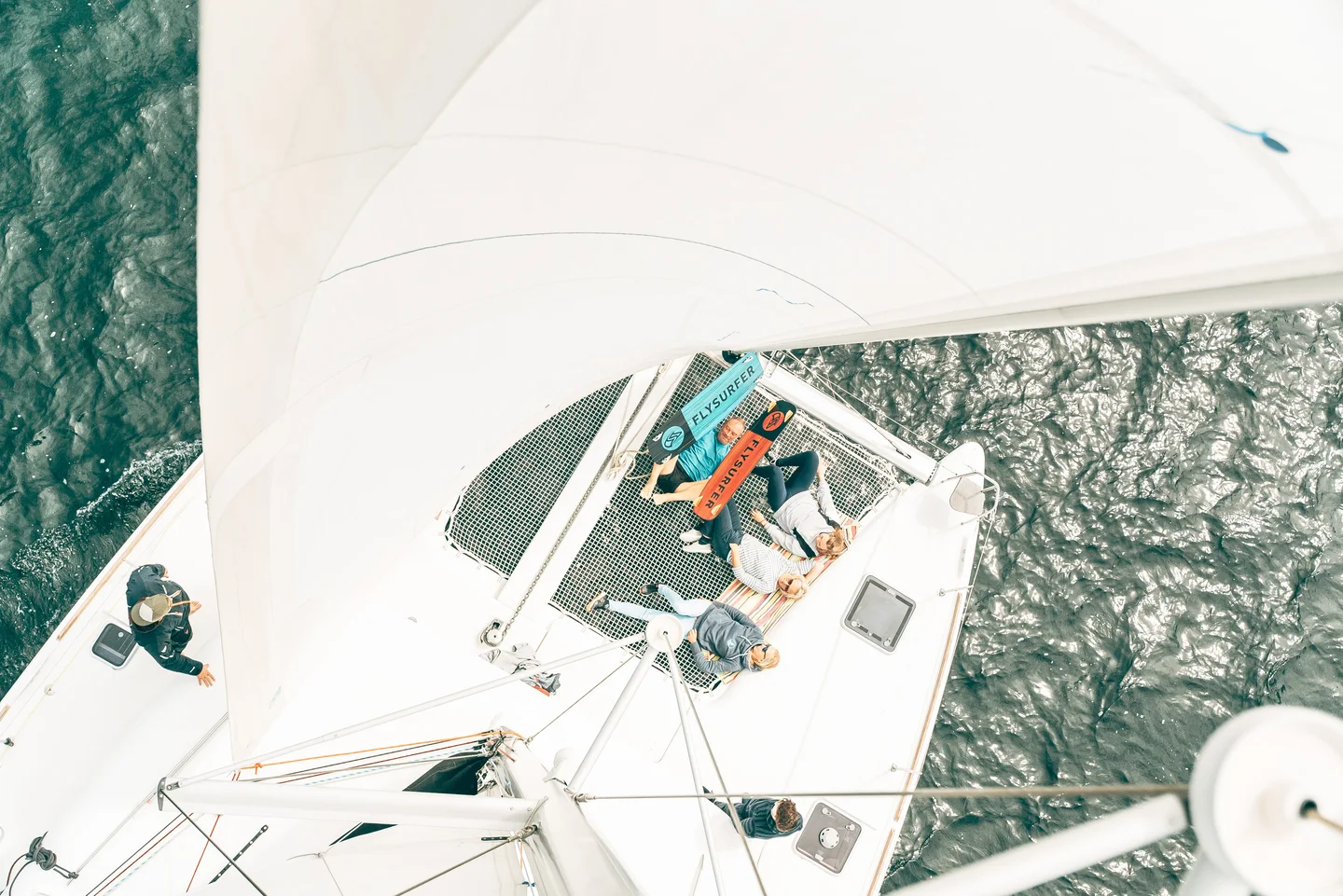 Mit Freunden auf dem Netz des Katamarans relaxen